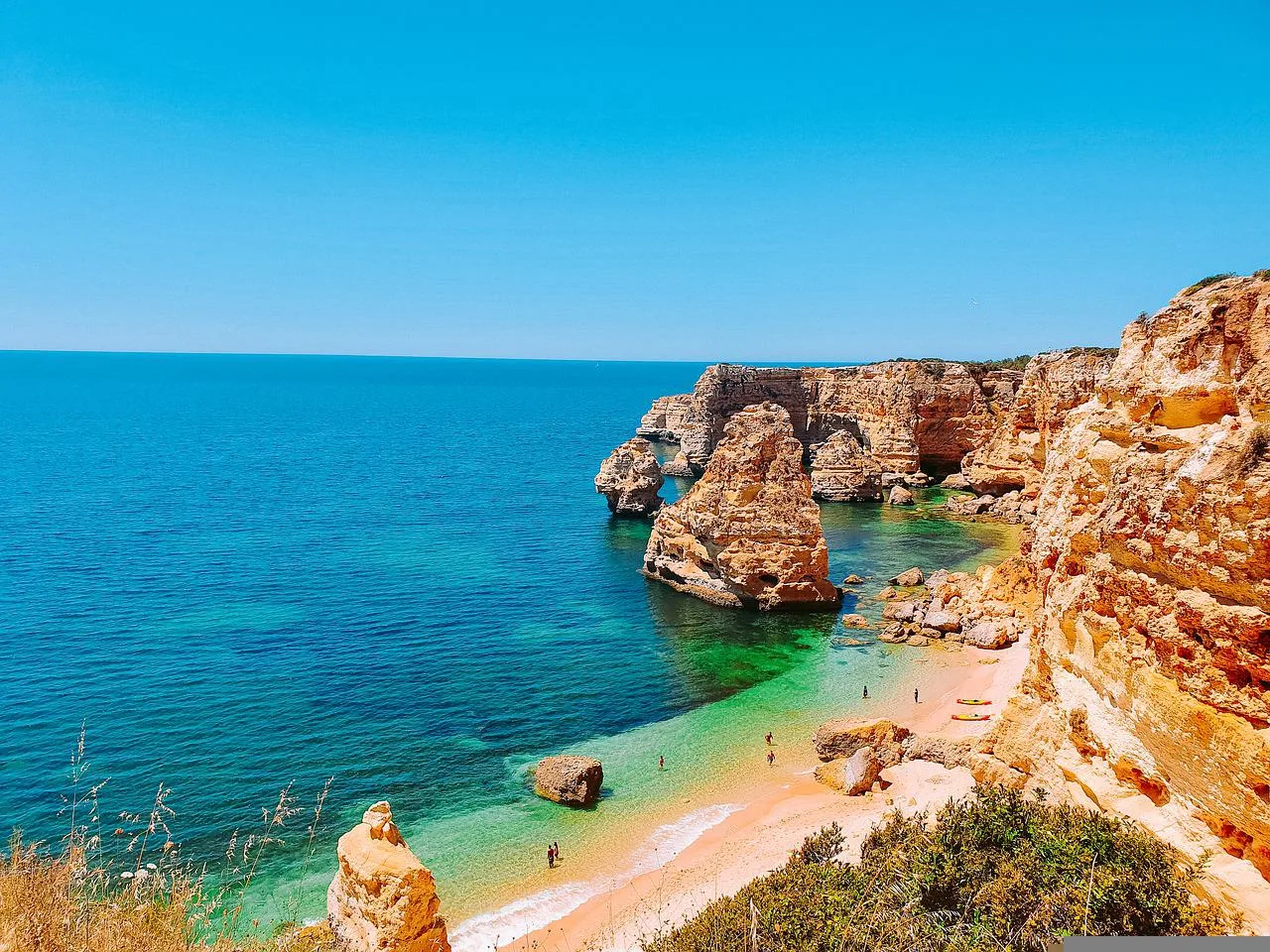 Falésias douradas e água turquesa numa praia algarvia